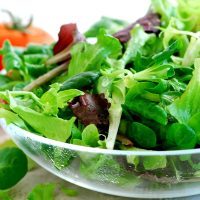Fresh baby greens salad and tomatoes close up