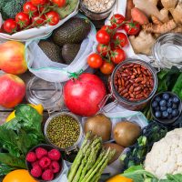 Textile mesh bag with produce, fruits and vegetables. Zero waste, eco friendly, plastic free recycled, reusable, sustainable grocery shopping concept. Flat lay background
